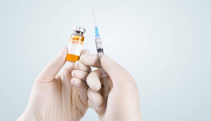 vecteezy_hand-holding-syringe-with-vaccine-against-corona-virus