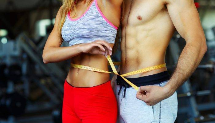 vecteezy_man-and-woman-with-measuring-tape-in-gym